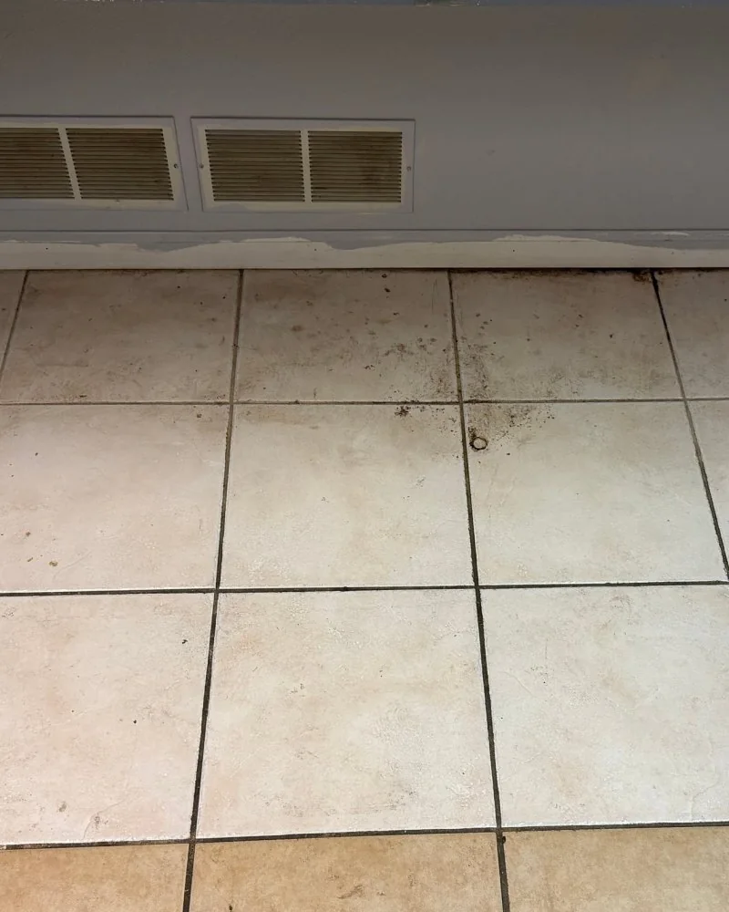 Dirty tile floor under a kitchen prep counter before cleaning in Lawrenceville, GA