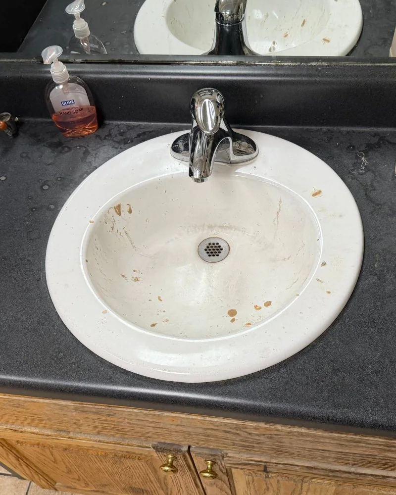 Stained restroom sink and counter before cleaning in Lawrenceville, GA
