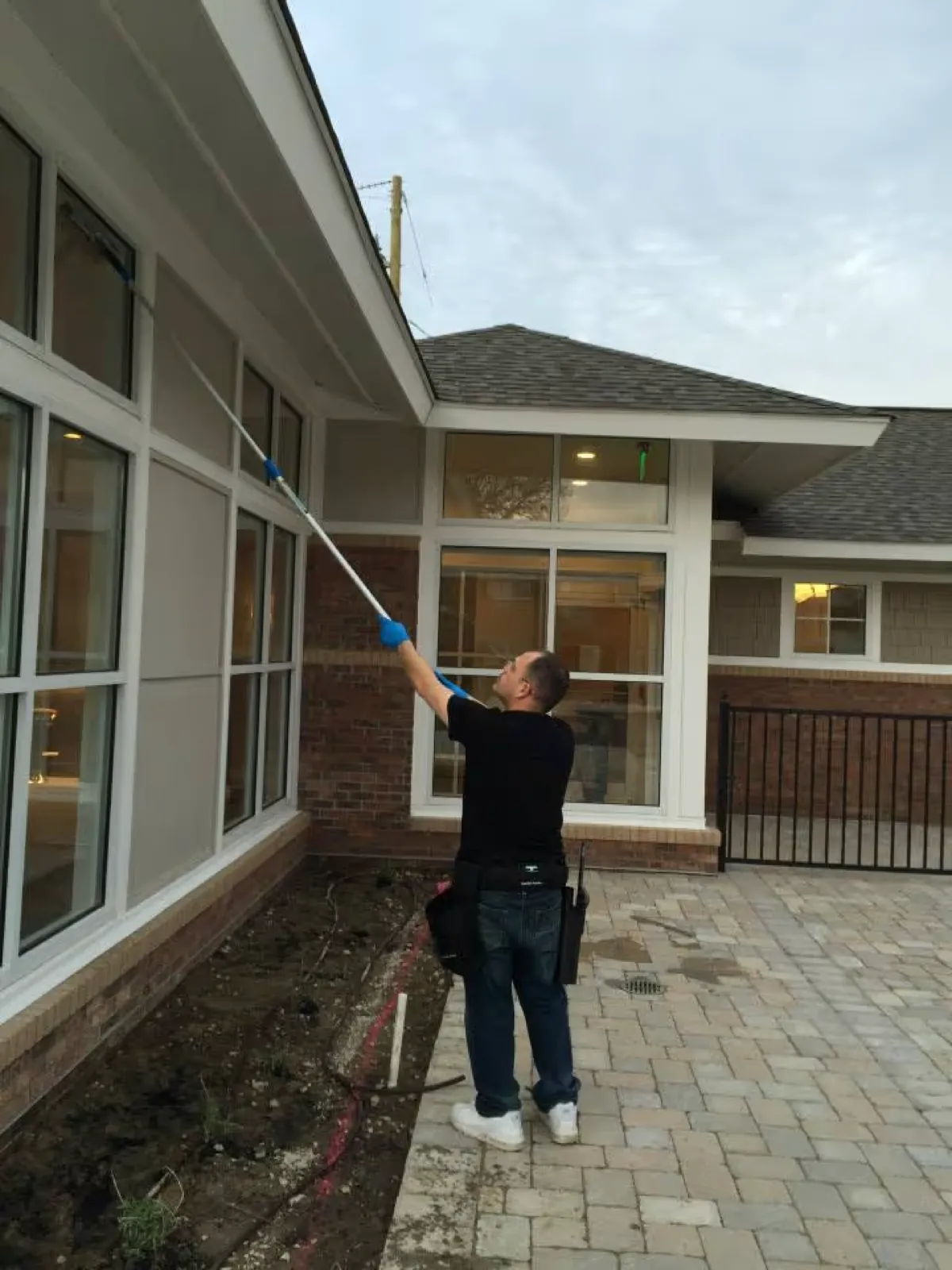 Cleaning the outside windows of a commercial building with a pole
